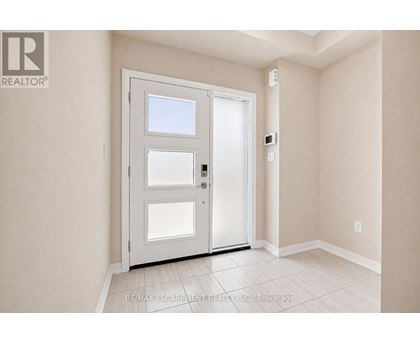 A white door with a window is in a room with white walls.