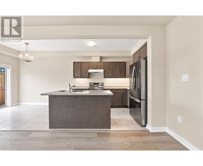 A modern kitchen with a stainless steel refrigerator and a central island.