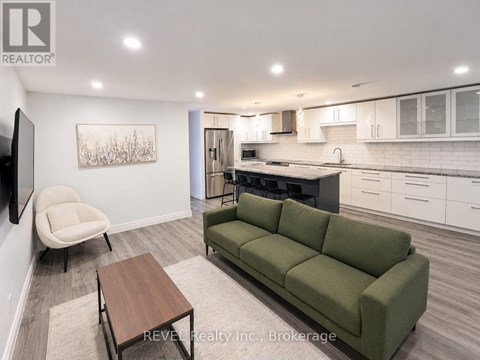 A living room with a green couch, a chair, and a coffee table.