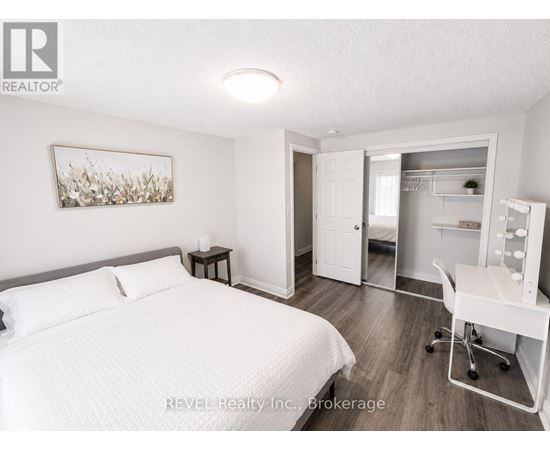 A bedroom with a bed, desk, and chair.