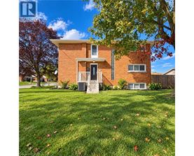 A house with a lawn and trees in front of it.