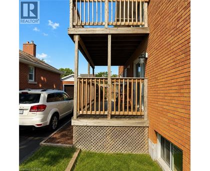A wooden balcony is attached to a brick building.