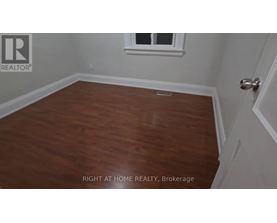 A room with wooden flooring and a window.
