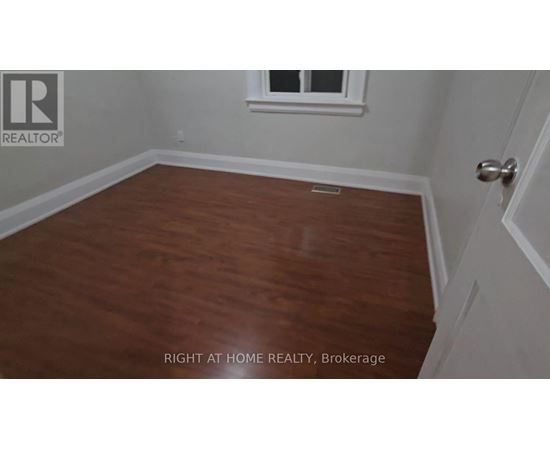 A room with wooden flooring and a window.