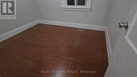 A room with wooden flooring and a window.
