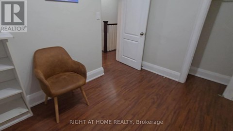 A brown chair sits in a room with white walls and a white door.