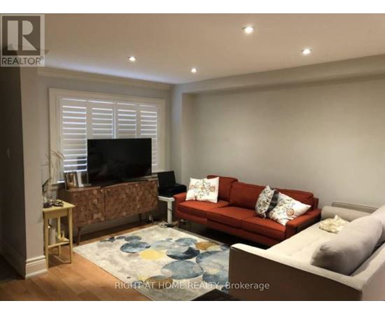 A living room with a red couch and a television.