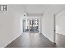 A spacious room with a view of a building through a glass door.