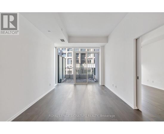 A spacious room with a view of a building through a glass door.