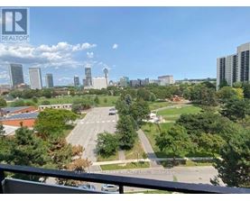 A cityscape with a clear blue sky and a few clouds.