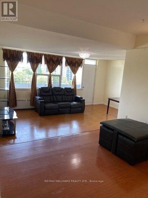 A living room with a black sofa and a wooden floor.