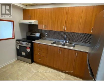 A kitchen with wooden cabinets and a black oven.
