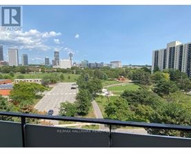 A view from a balcony overlooking a parking lot and buildings.