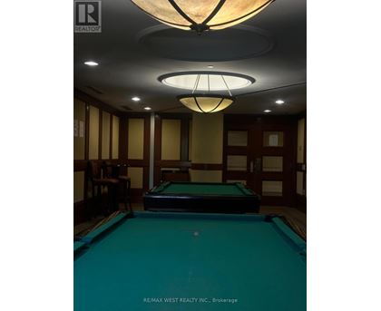 A pool table in a room with a light hanging from the ceiling.