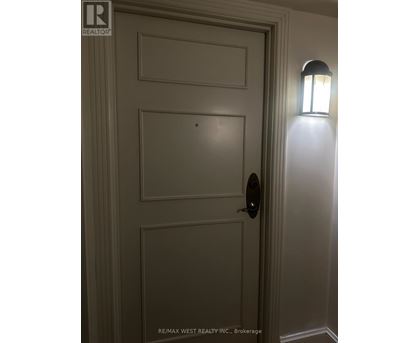 A white door with a black handle and a light on the side.