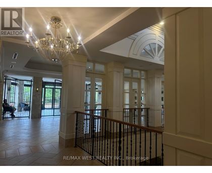 A chandelier hangs from the ceiling in a spacious lobby.