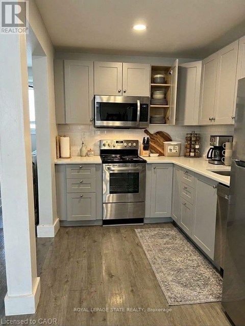 A kitchen with white cabinets and stainless steel appliances.