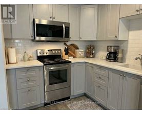 A kitchen with a stove, microwave, and cabinets.