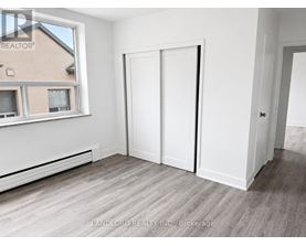 A room with a window, a door, and a wall with a window.