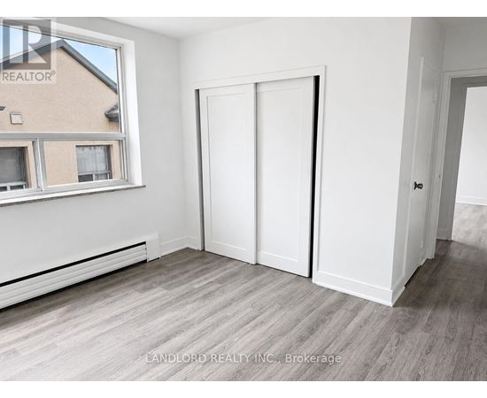 A room with a window, a door, and a wall with a window.