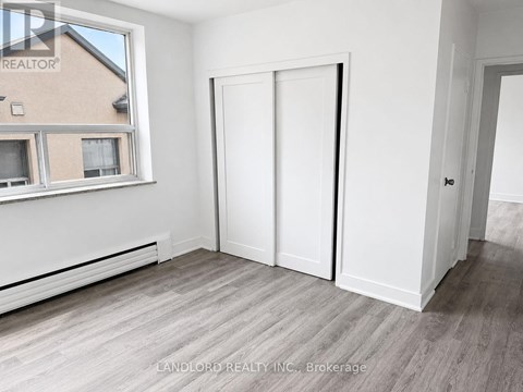 A room with a window, a door, and a wall with a window.