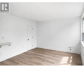 A room with a white door and a window with sunlight coming through.