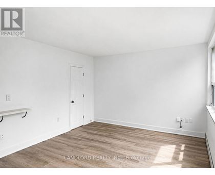A room with a white door and a window with sunlight coming through.