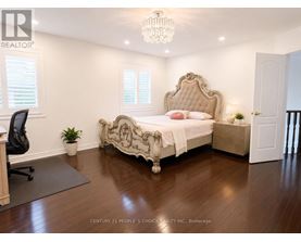 A bedroom with a large bed and a chandelier.