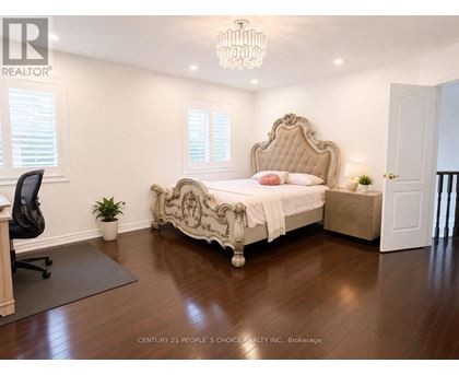 A bedroom with a large bed and a chandelier.