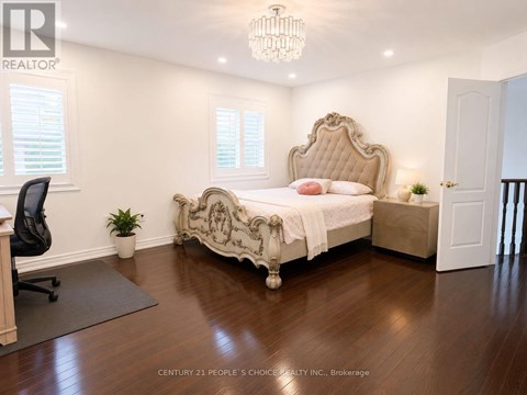 A bedroom with a large bed and a chandelier.