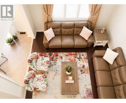 A living room with a brown couch and a floral rug.