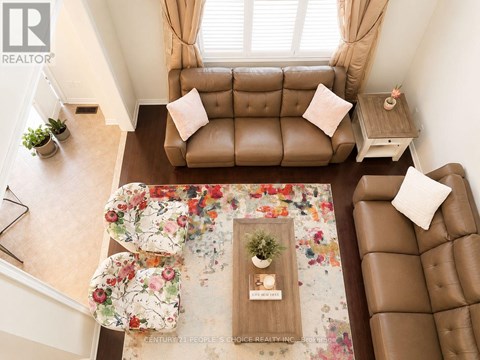 A living room with a brown couch and a floral rug.