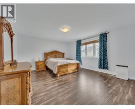 A bedroom with a bed, dresser, and mirror.