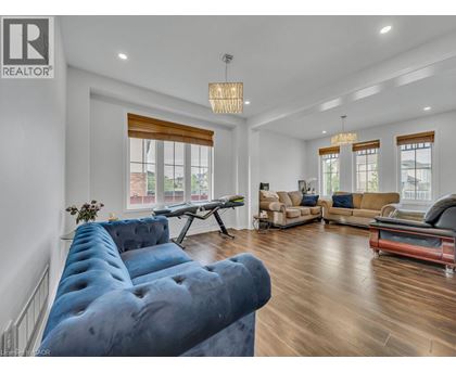 A living room with a blue couch and a wooden floor.