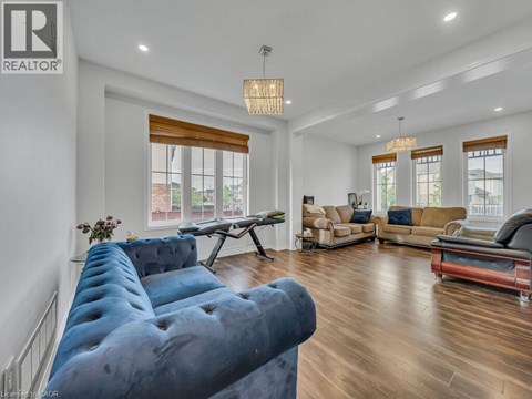 A living room with a blue couch and a wooden floor.