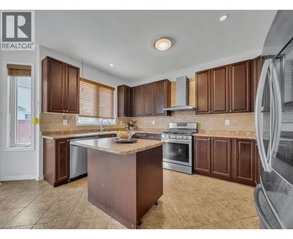 A kitchen with brown cabinets and a large island.