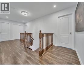 A spacious room with a wooden staircase and white walls.