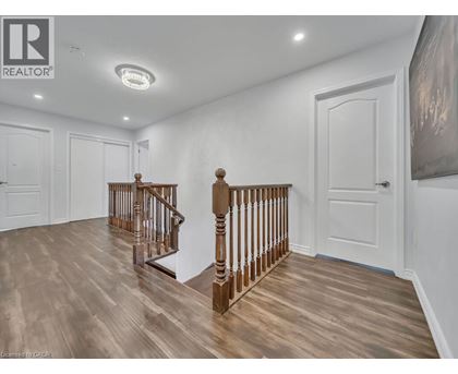 A spacious room with a wooden staircase and white walls.