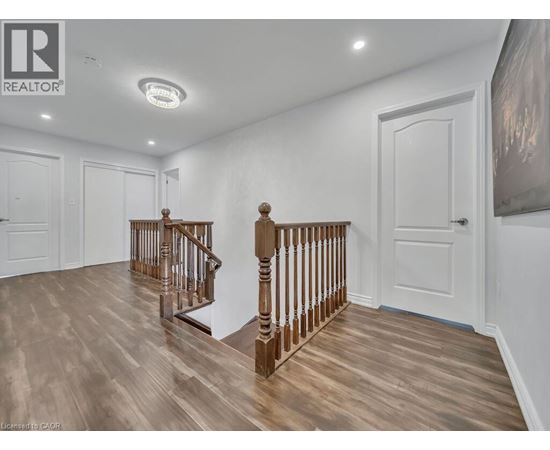 A spacious room with a wooden staircase and white walls.