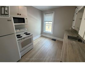A kitchen with white appliances and a window.