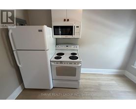 A white refrigerator and oven in a kitchen.