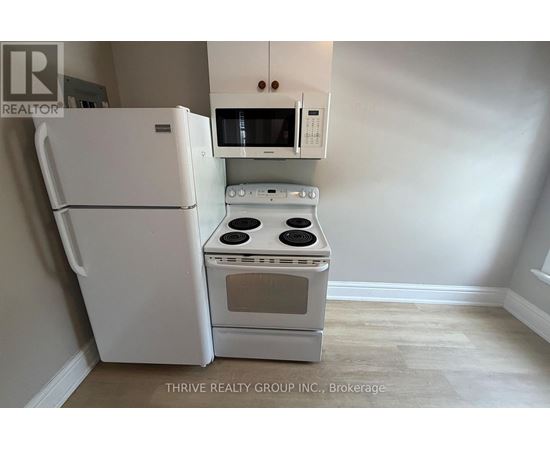 A white refrigerator and oven in a kitchen.