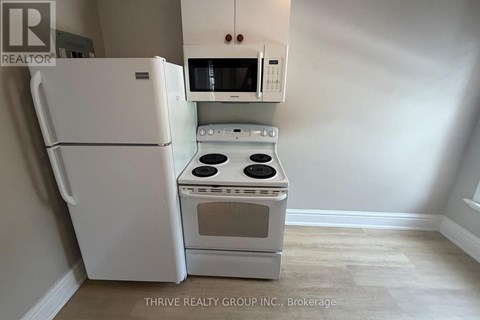 A white refrigerator and oven in a kitchen.