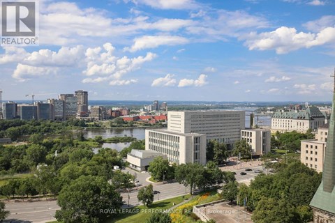 A cityscape with a large building in the center and a body of water in the foreground.