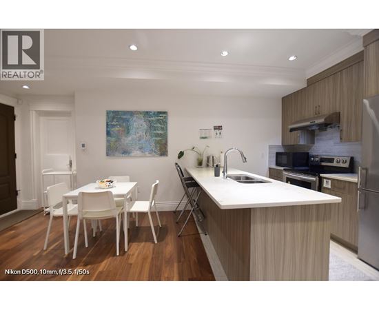 A kitchen with a dining table and chairs.
