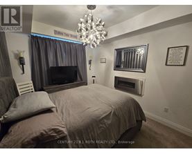 A bedroom with a large bed and a chandelier.