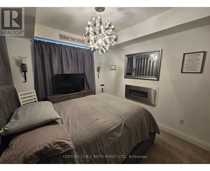A bedroom with a large bed and a chandelier.