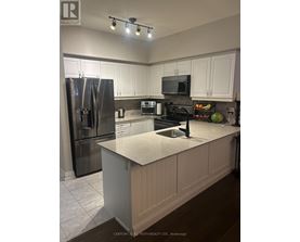 A kitchen with white cabinets and a granite countertop.