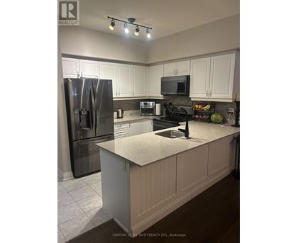 A kitchen with white cabinets and a granite countertop.