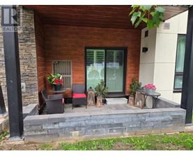 A patio with a table and chairs is in front of a house.